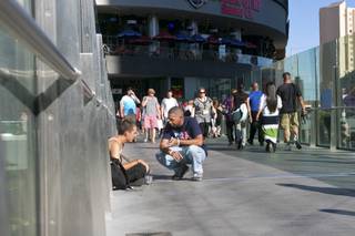 Marcus Mitchell, a local Las Vegas gambler who donates a majority of his winnings to those in need, converses with a young homeless man on a pedestrian bridge crossing the Strip, Tuesday Aug. 13, 2013.  Since the passing of his wife in 2008, Marcus has been finding ways to randomly help people he comes in contact with, either in person or online.